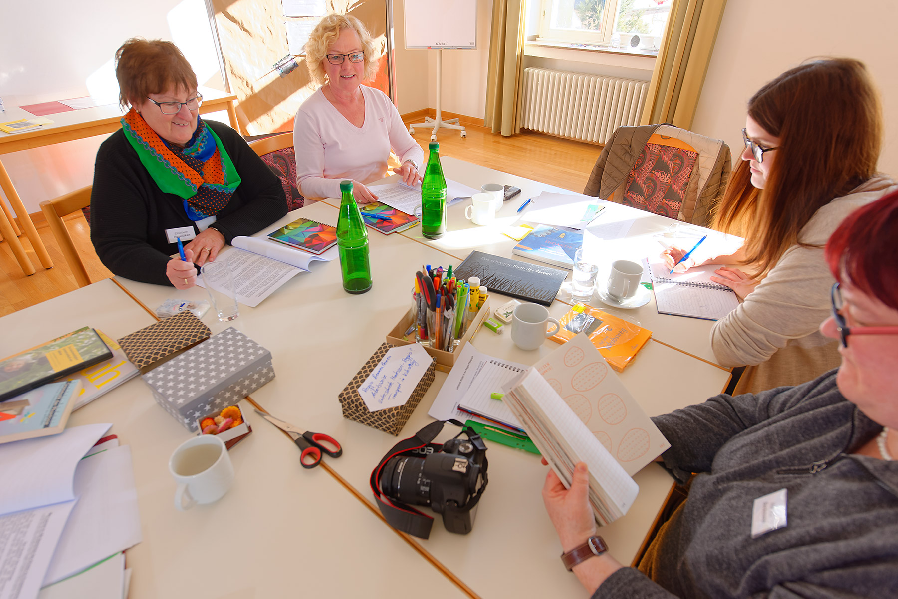 Gruppe arbeitet am Tisch und tauscht sich aus.